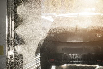 Car in a wash bay being sprayed with water