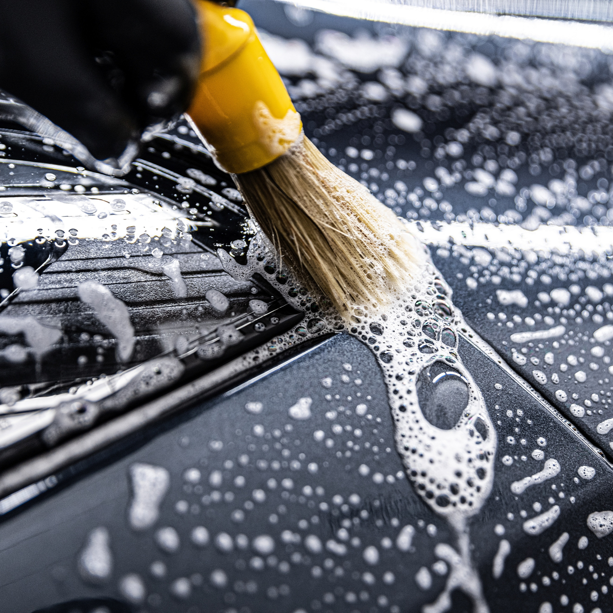 Foam brush cleaning a vehicle, illustrating AutoBrite Foam Brush Concentrate use