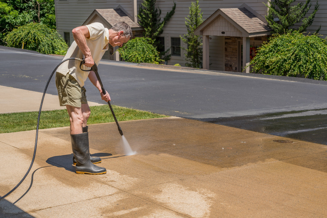 Man pressure washing a concrete surface